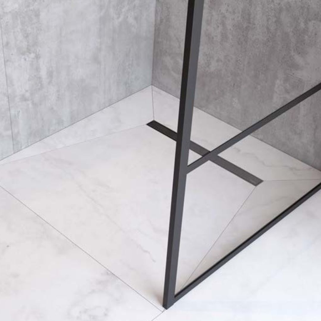 A modern shower enclosure corner with a matte black metal frame and a geometric floor drain, set against gray textured walls and a white marble-look tiled floor.