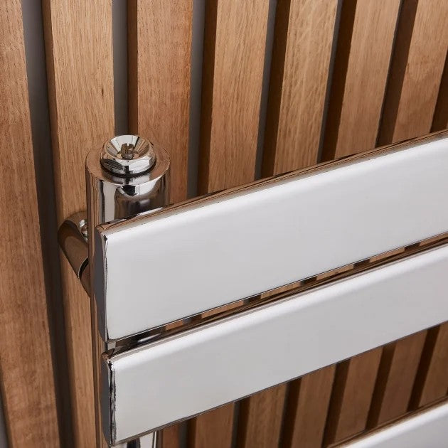 White radiator with chrome finish mounted on a wooden wall.
