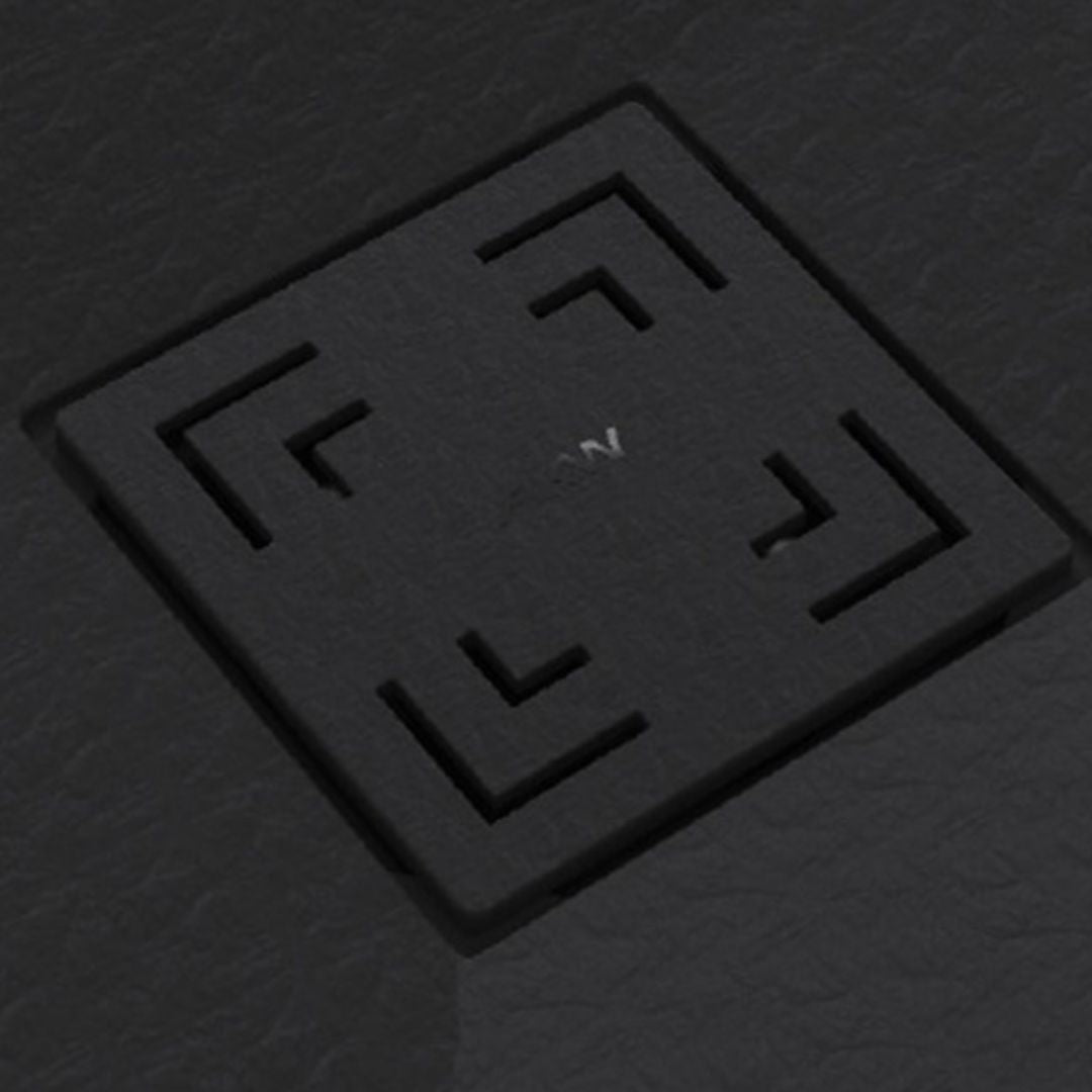 A square black textured cover with recessed corner cutouts and a small white symbol in the center, shown on a dark gray textured background.