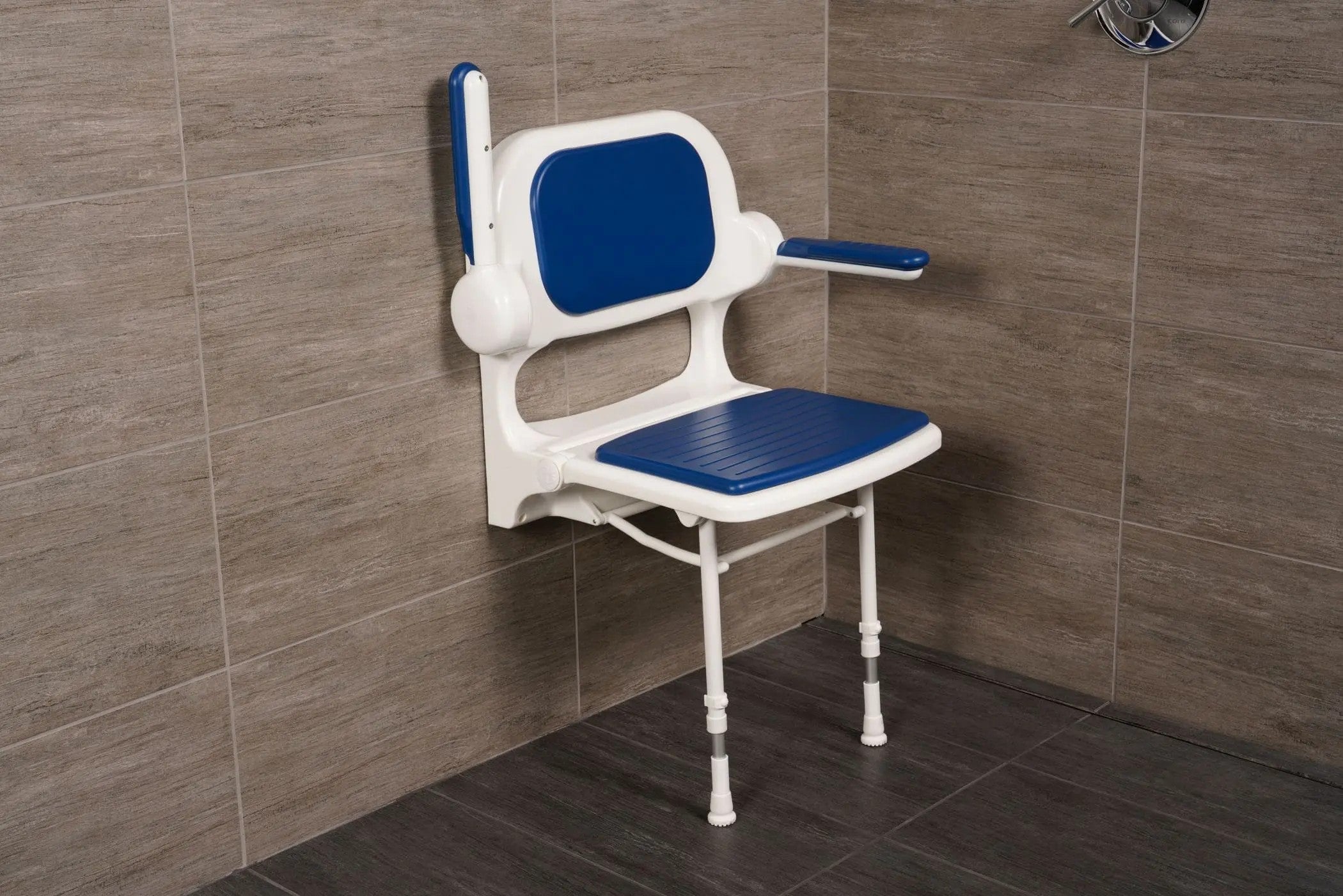 Blue and white adjustable shower seat against a tiled bathroom wall.
