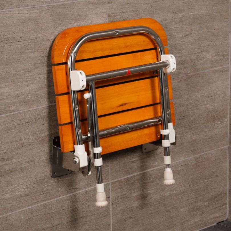 A wall-mounted folding shower seat with an oak wood-look slatted backrest and a chrome metal frame, attached to a gray tiled wall.