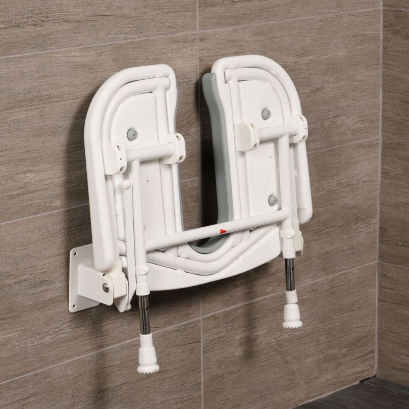 A horseshoe shower seat folded against the wall