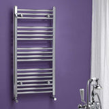 Chrome towel radiator against a purple wall with bathroom fixtures.