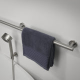Gray towel hanging on a metal towel rack with a shower head in the background.