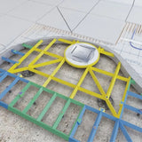 A robotic floor screed leveling system with a circular white and gray robot positioned over a yellow metal support frame, with green and blue guide rails on a concrete floor.