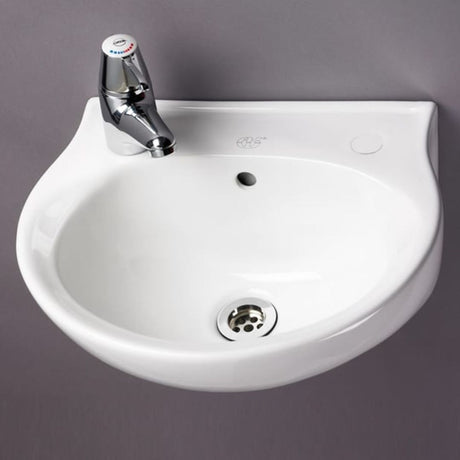 A white ceramic wall-mounted bathroom sink with a chrome faucet, shown against a solid dark grey background.