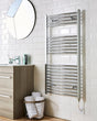 Bathroom with a towel radiator, sink, and mirror on a tiled wall.