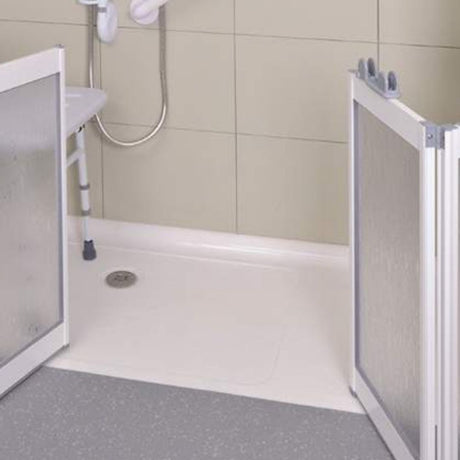A shower door safety screen with textured clear panels and white frames installed on both sides of a white shower base in a tiled bathroom.