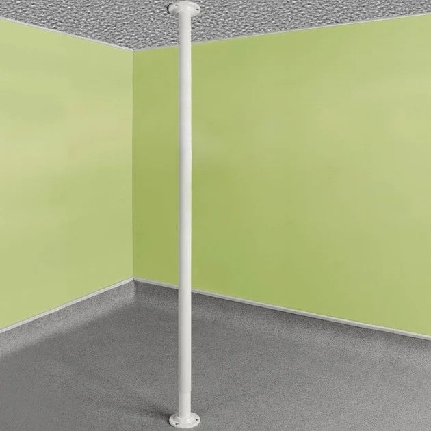 White pole against a corner of a room with green walls and gray floor.