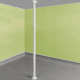 White pole against a corner of a room with green walls and gray floor.