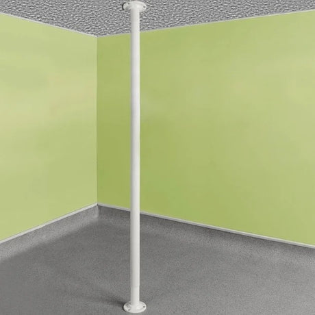 White pole against a corner of a room with green walls and gray floor.