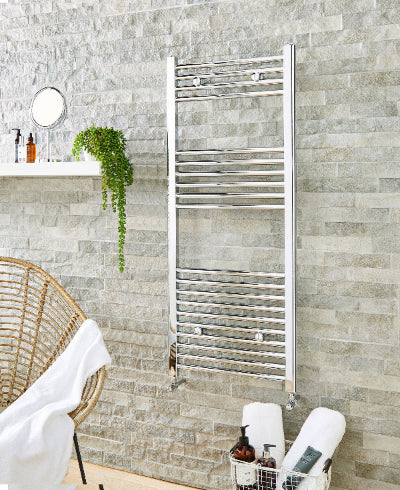Chrome heated towel rail in modern bathroom setting