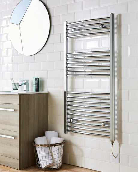 Bathroom with a towel radiator, sink, and mirror on a tiled wall.