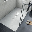 Modern bathroom shower tray with a shower area featuring a drain and tiled walls.
