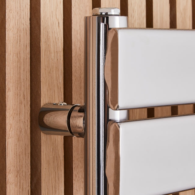 Close-up of a modern towel radiator with wooden slats in the background