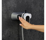 Hand washing device mounted on a dark wall with a hand using it.