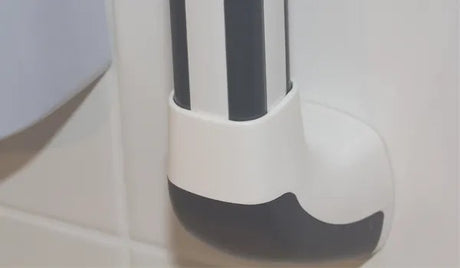White and gray object with a black mustache design on a light gray background