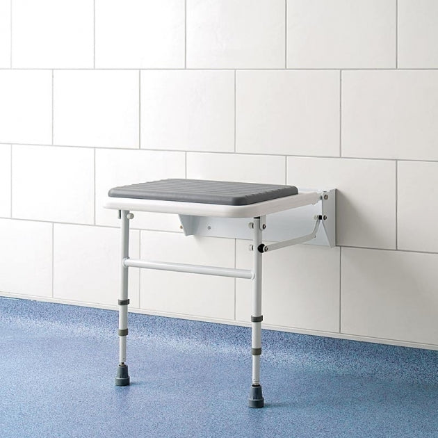 Wall-mounted adjustable shower seat against a white tiled wall.