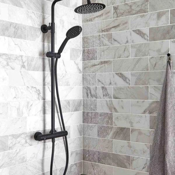 Shower setup with black fixtures on a tiled shower wall.