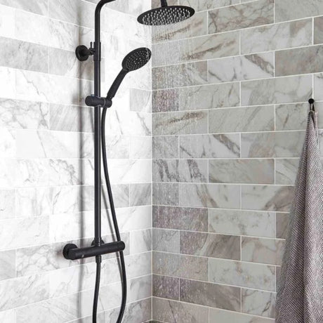 Shower setup with black fixtures on a tiled shower wall.