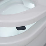 Close-up of a white toilet seat with a small black seat lugs positioned underneath the rim.