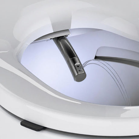 Close-up of a white toilet seat with an integrated bidet sprayer and water stream visible inside the bowl.