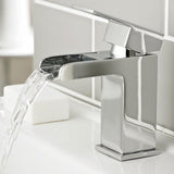 Chrome bathroom faucet with water flowing in a bathroom setting