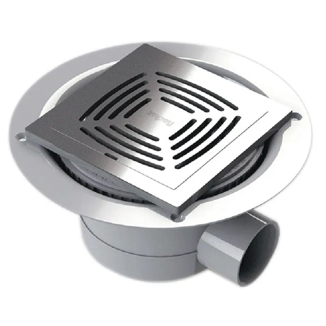 A square tiled stainless steel wetroom waste with a slotted grate cover, set inside a round gray drain flange with a gray pipe outlet.