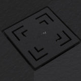 A square black textured cover with recessed corner cutouts and a small white symbol in the center, shown on a dark gray textured background.