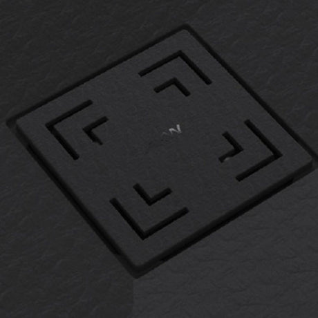 A square black textured cover with recessed corner cutouts and a small white symbol in the center, shown on a dark gray textured background.