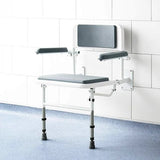 White shower seat with grey padding against a wall